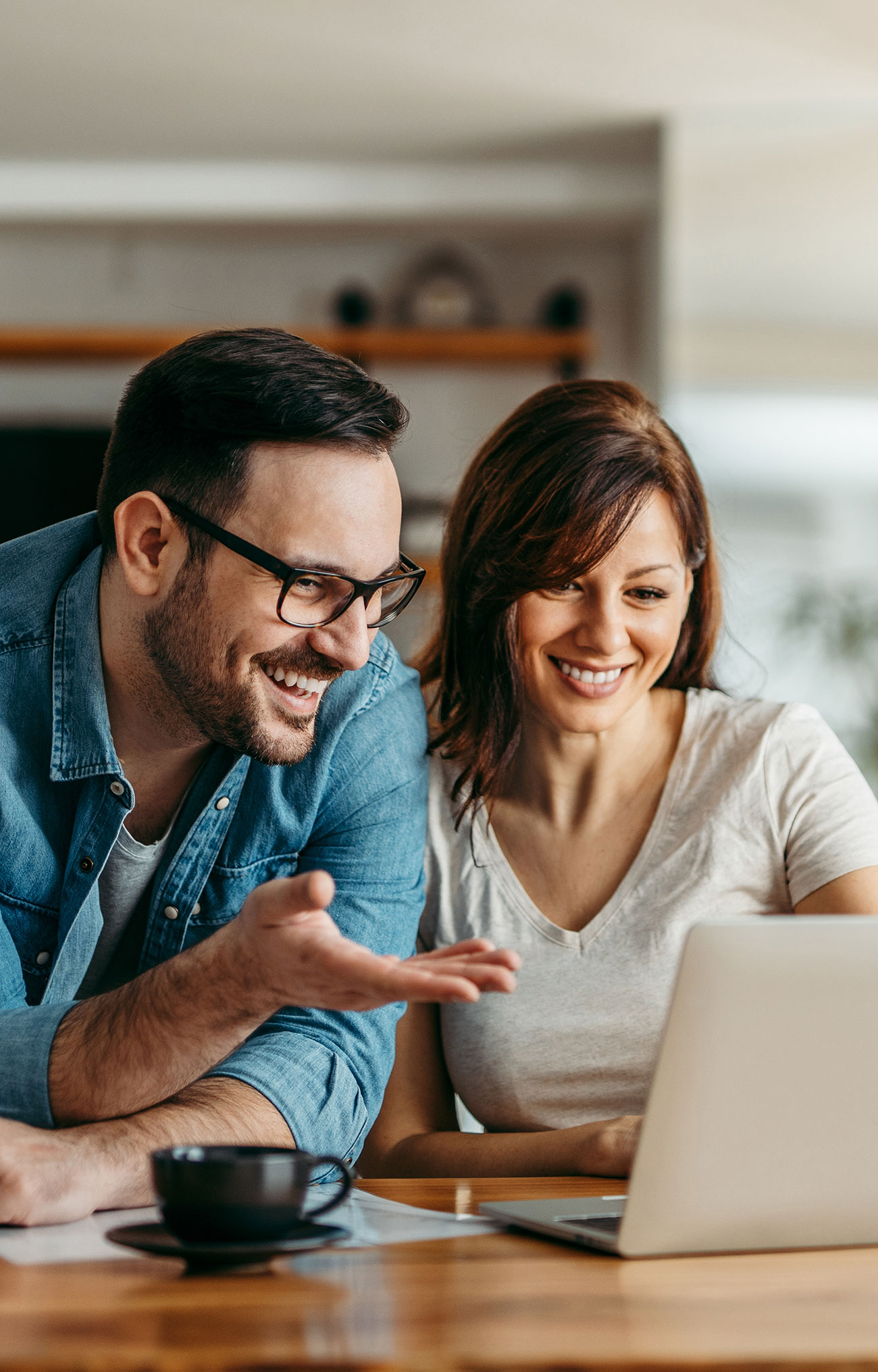 "Couple souriant utilisant un ordinateur portable ensemble à la maison"